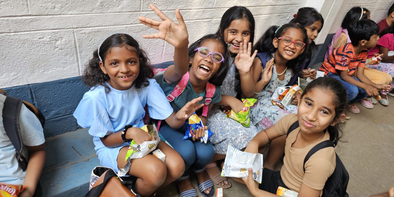 Children sitting and waving their hands with joy during snack time during VBS at City Harvest Church